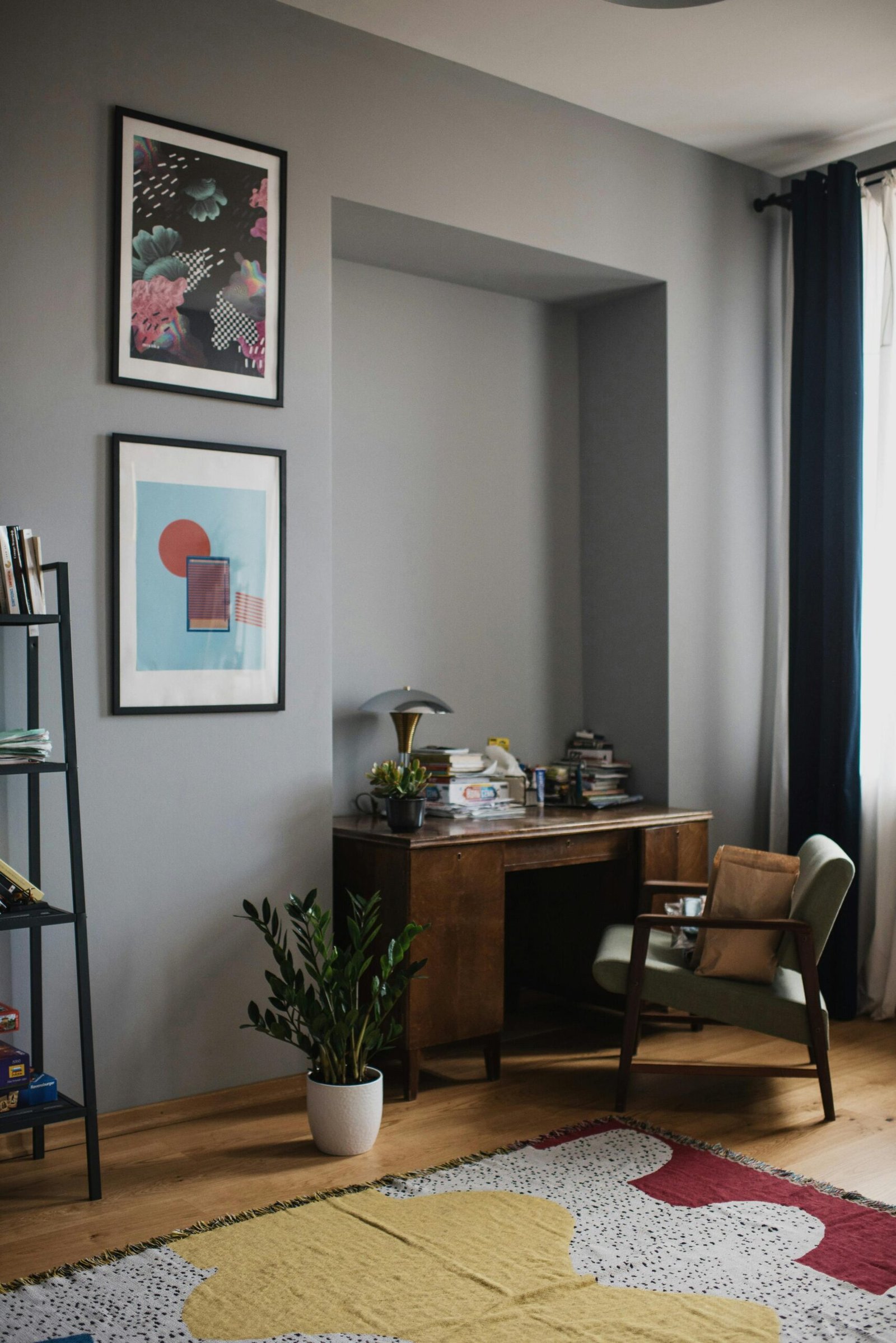 Cozy home office with vintage desk, artwork, and natural light ambiance.